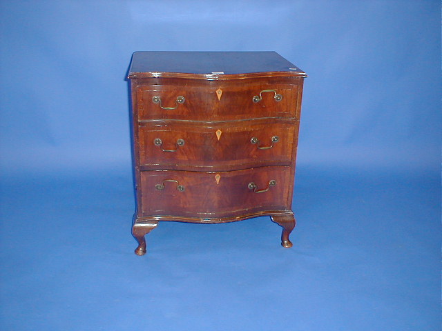 Appraisal: A reproduction mahogany serpentine chest with crossbanded top wide