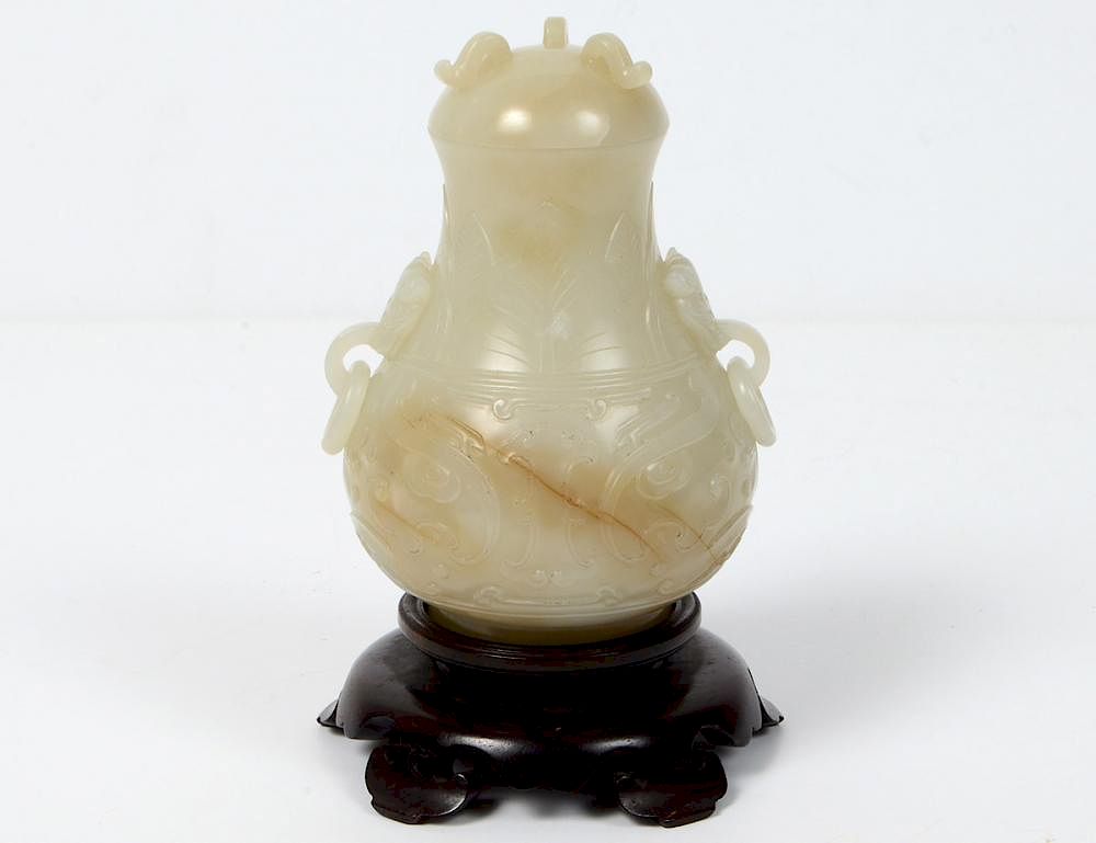 Appraisal: CHINESE ARCHAISTIC COVERED VASE The white jade pear-form vessel with