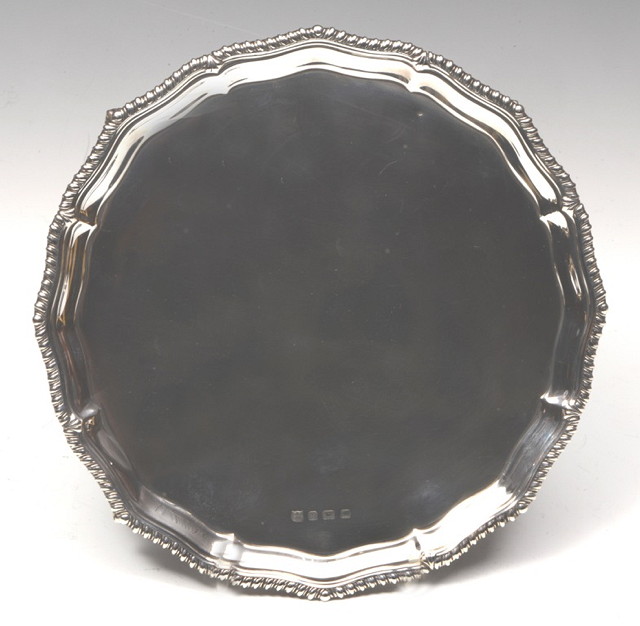 Appraisal: A SILVER WAITER with shaped gadrooned border and standing on