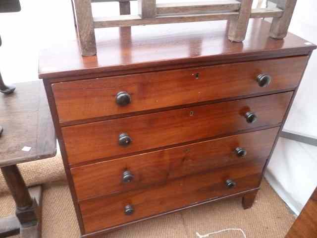 Appraisal: A MAHOGANY CHEST of four long drawers with turned knob