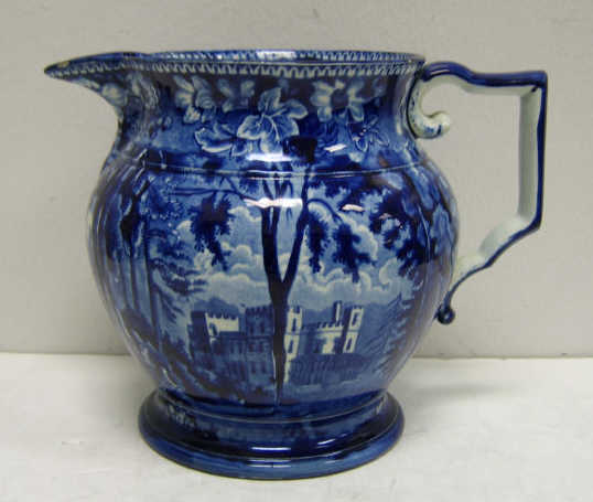 Appraisal: STAFFORDSHIRE BLUE TRANSFER POTTERY JUG Footed with shaped angular handle