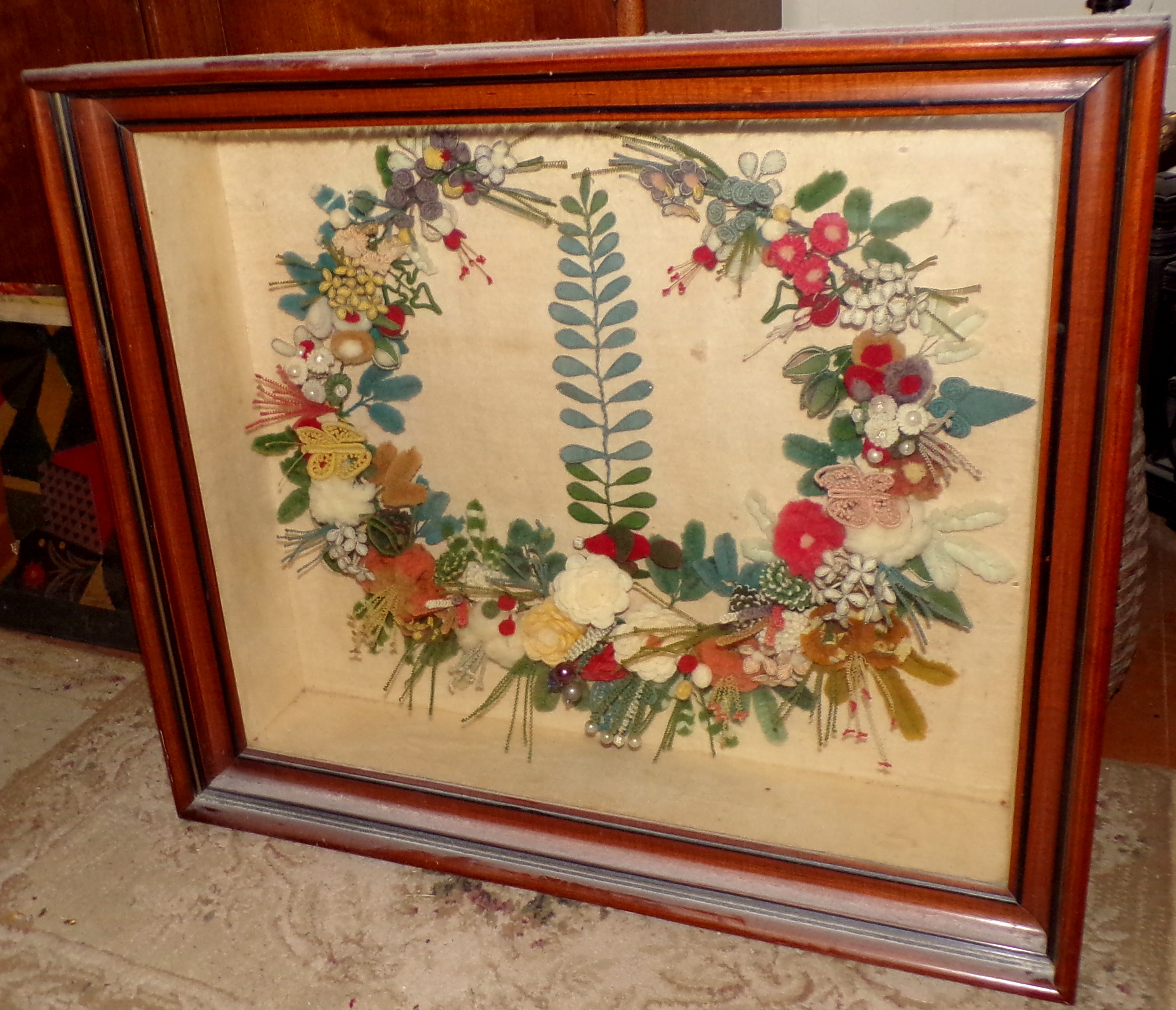 Appraisal: Victorian textile wreath set in walnut shadow box frame exterior