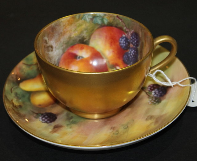 Appraisal: A ROYAL WORCESTER CUP AND SAUCER with hand painted fruit