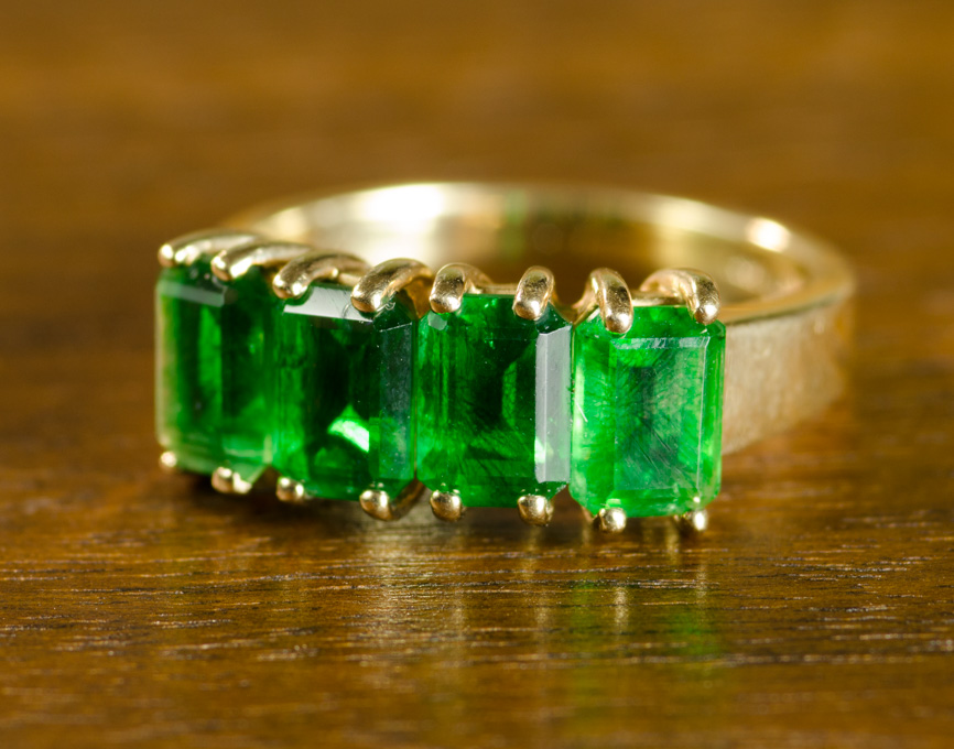 Appraisal: EMERALD AND TEN KARAT GOLD RING set with four emerald-cut