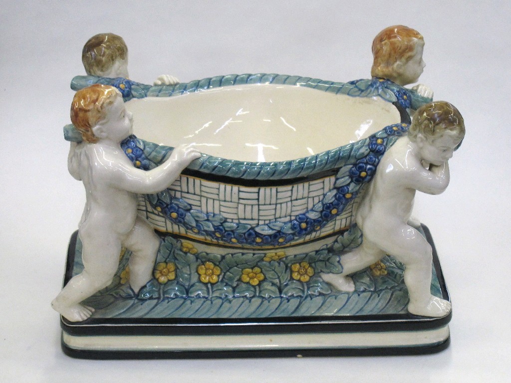 Appraisal: Continental pottery centrepiece modelled as four putti carrying a basket