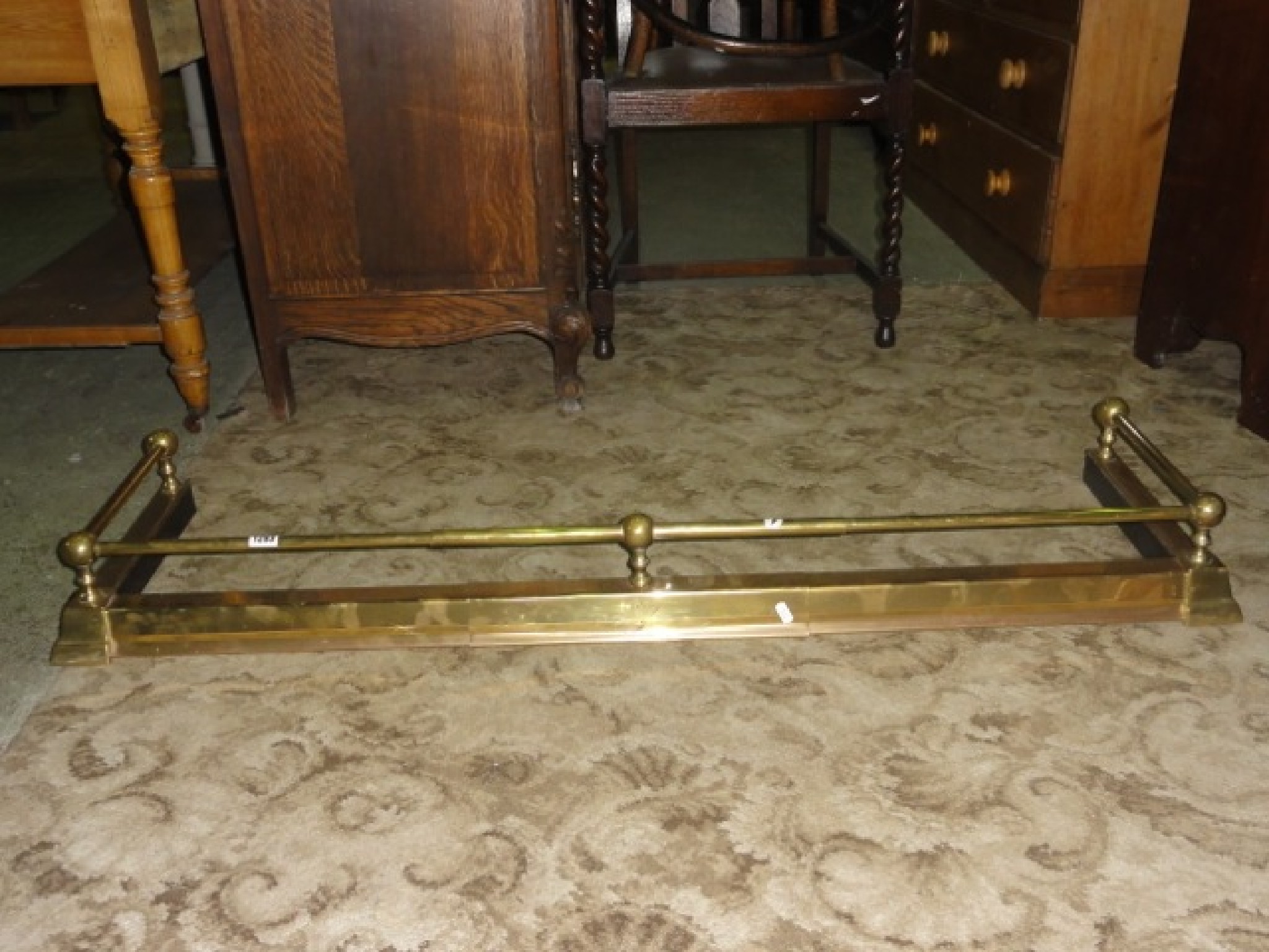 Appraisal: A polished brass fender with adjustable moulded curb beneath a