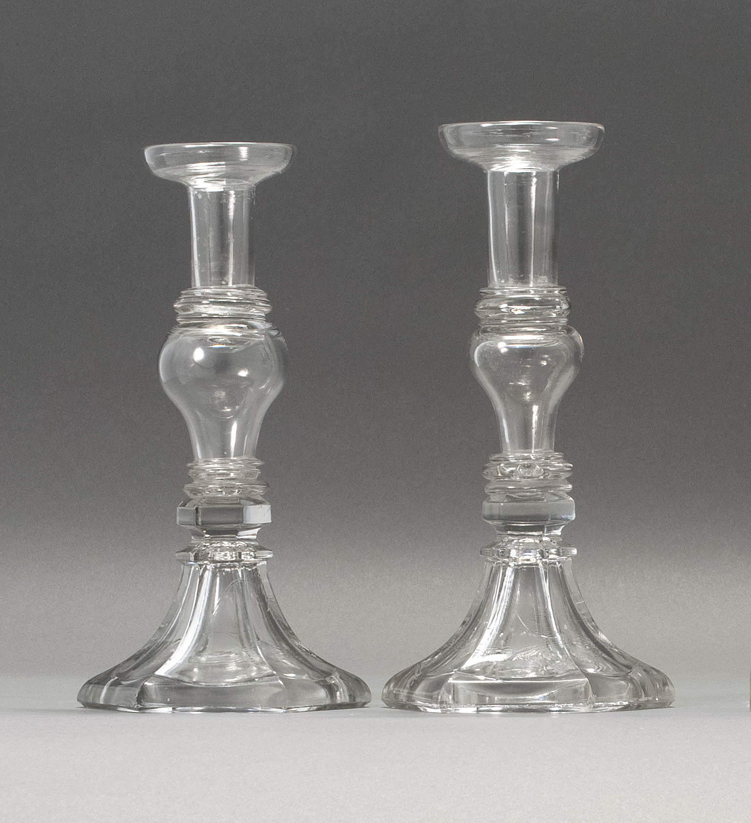 Appraisal: PAIR OF SANDWICH GLASS COMPANY CLEAR GLASS CANDLESTICKS Second Quarter