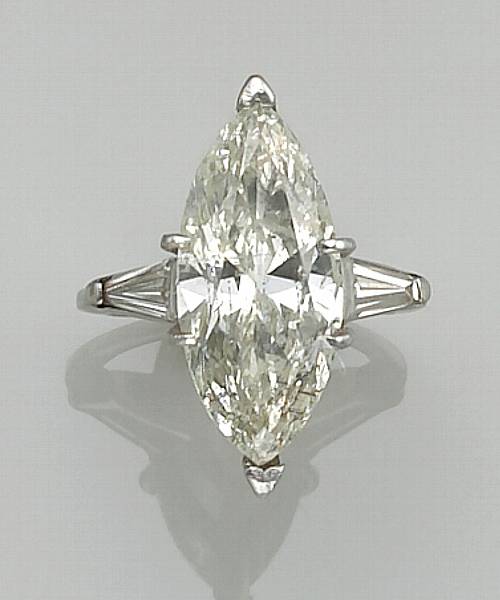 Appraisal: A diamond and platinum ring centering a marquise-cut diamond flanked