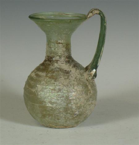 Appraisal: A Roman pale green irridescent glass bottle with handle cm