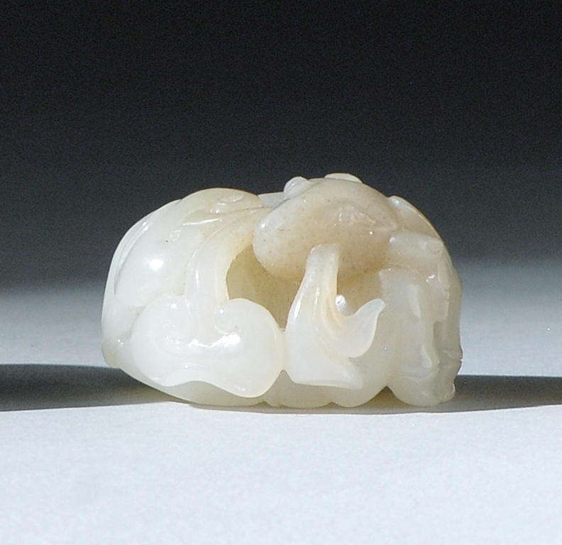 Appraisal: BROWN AND WHITE JADE CARVING In the form of a