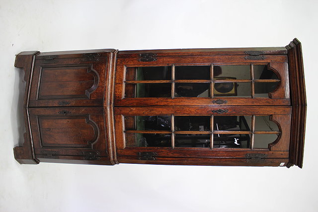 Appraisal: A FLOOR STANDING OAK CORNER CUPBOARD with angled glazed doors