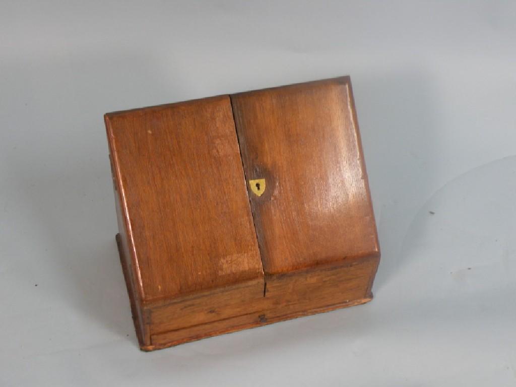 Appraisal: An Edwardian oak writing cabinet with a slope top and