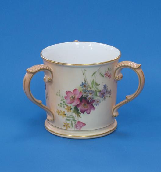 Appraisal: A ROYAL WORCESTER BLUSH IVORY LOVING CUP decorated with coloured