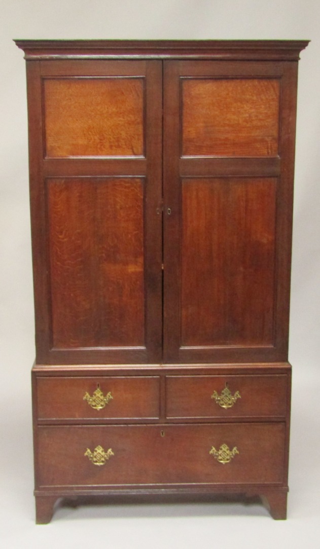 Appraisal: A George III oak linen press the pediment over two