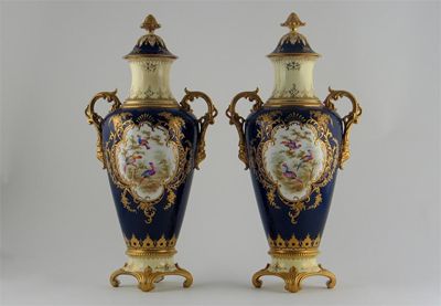 Appraisal: A pair of Coalport twin-handled vases and covers painted with