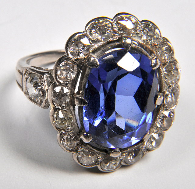 Appraisal: A LADIES RING with central synthetic sapphire settings surrounded by