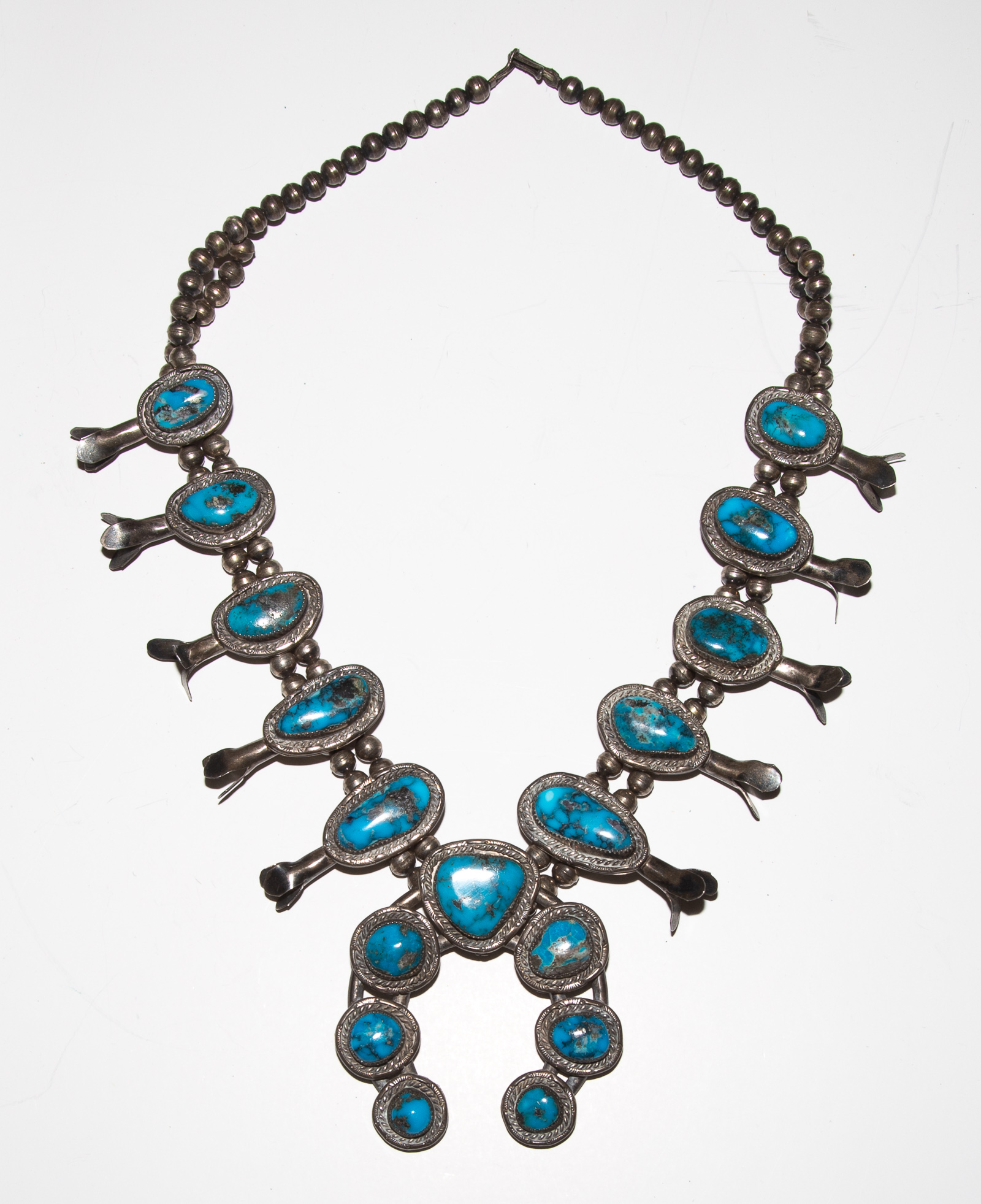 Appraisal: A BOLD TURQUOISE SQUASH BLOSSOM NECKLACE Southwest tribe sterling silver