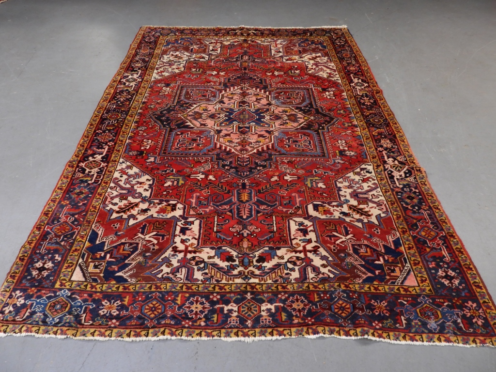 Appraisal: PERSIAN HERIZ CARPET RUG Persia th CenturyCentral medallion over red