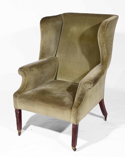 Appraisal: A th Century green upholstered wingback armchairon mahogany tapering supports