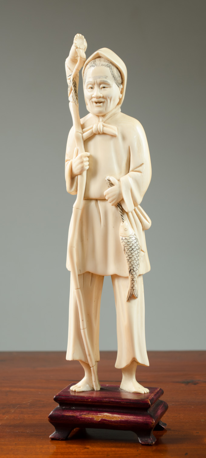 Appraisal: CHINESE CARVED IVORY FISHERWOMAN featuring a standing woman holding a