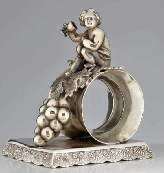 Appraisal: Cherub with Wine Glass Figural Napkin Ring Grapes in front