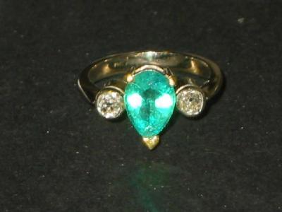 Appraisal: AN EMERALD AND DIAMOND RING the central marquise-cut emerald flanked