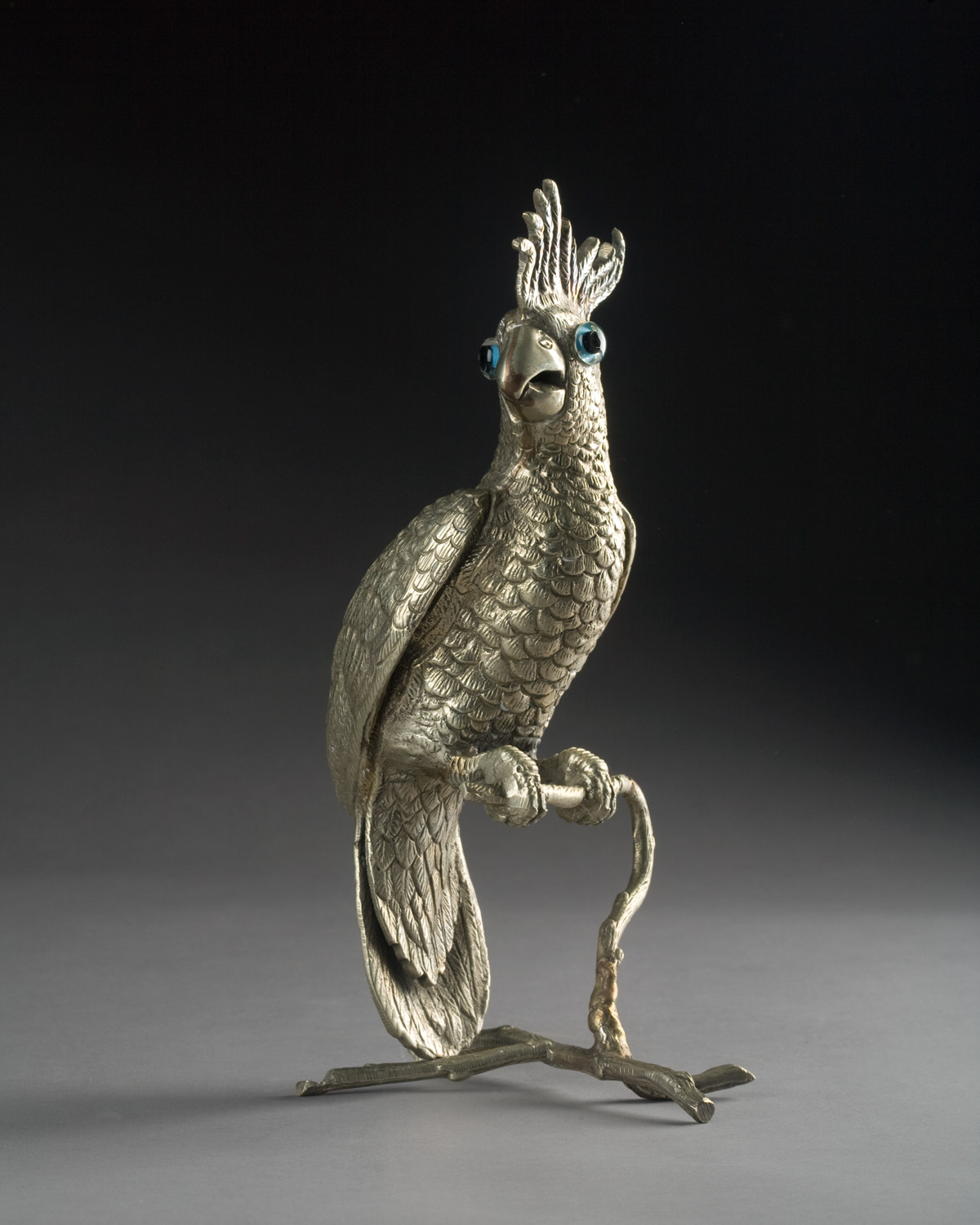 Appraisal: CONTINENTAL SILVERED-BRASS FIGURE OF A COCKATOO Mounted with black and