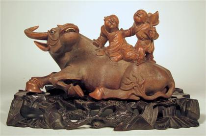 Appraisal: Chinese carved hardwood buffalo and boy model on standRecumbent beast