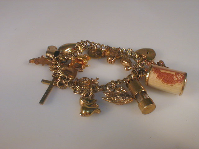 Appraisal: A ct gold charm bracelet with fifteen attached charms total