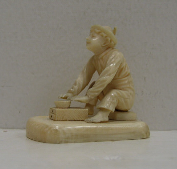 Appraisal: CARVED IVORY MINIATURE FIGURE A boy playing game circa Height