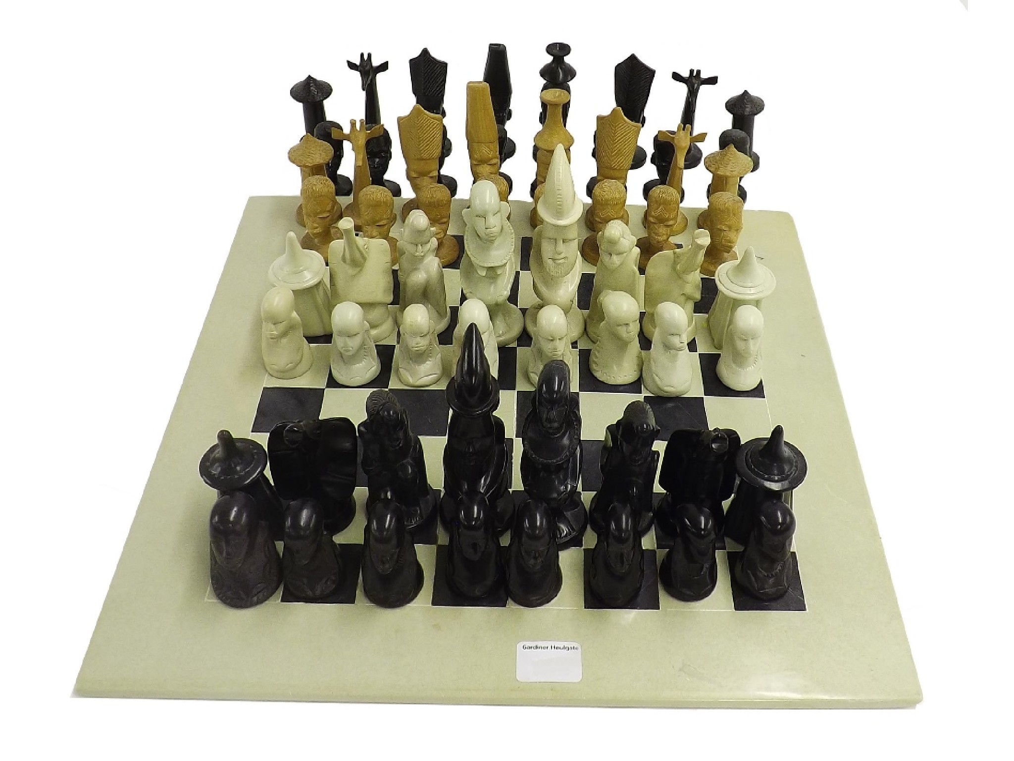 Appraisal: African carved soapstone chess set and board together with a