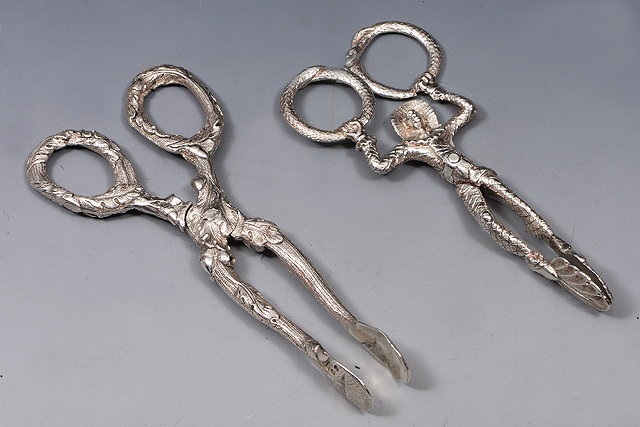 Appraisal: A PAIR OF VICTORIAN SILVER SUGAR NIPS with leaf and