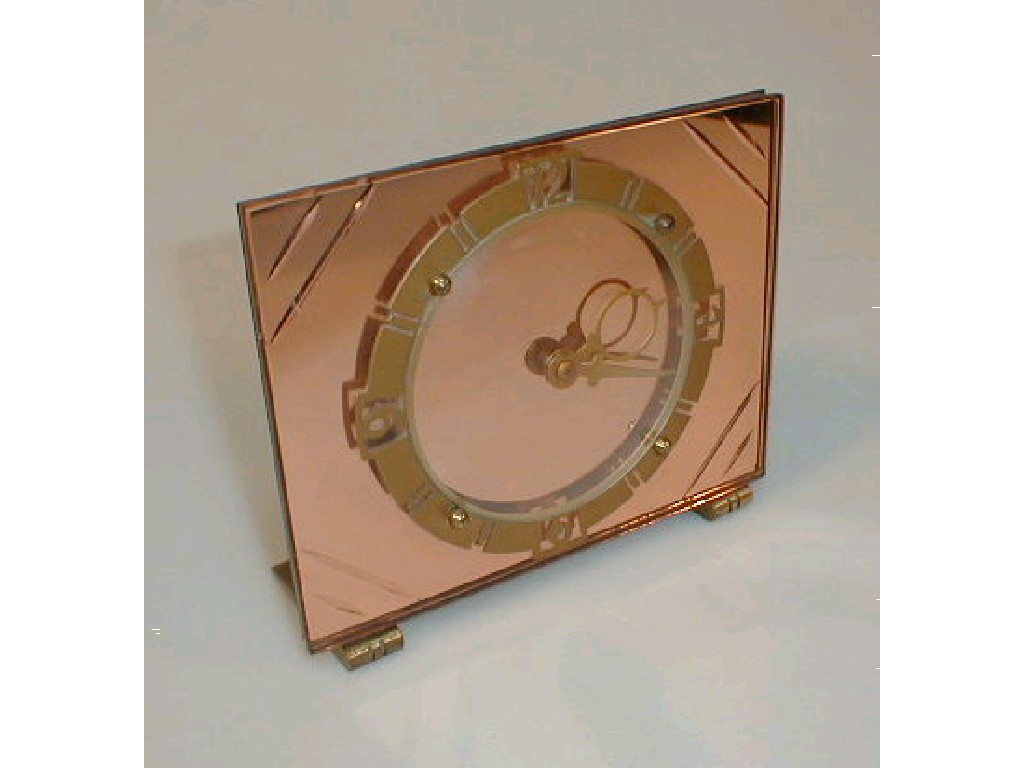 Appraisal: An Art Deco table clock with coloured mirrored backing and