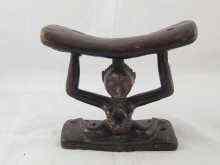 Appraisal: An African neck rest carved as a naked woman supporting