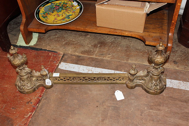 Appraisal: A FRENCH GILT BRASS ADJUSTABLE FENDER with scroll pierced facade