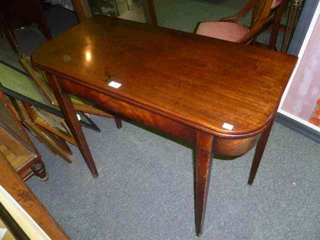 Appraisal: A GEORGIAN MAHOGANY FOLDOVER TOP TEA TABLE on square taper