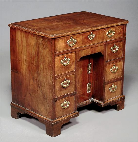 Appraisal: A George II walnut kneehole desk circa the crossbanded and