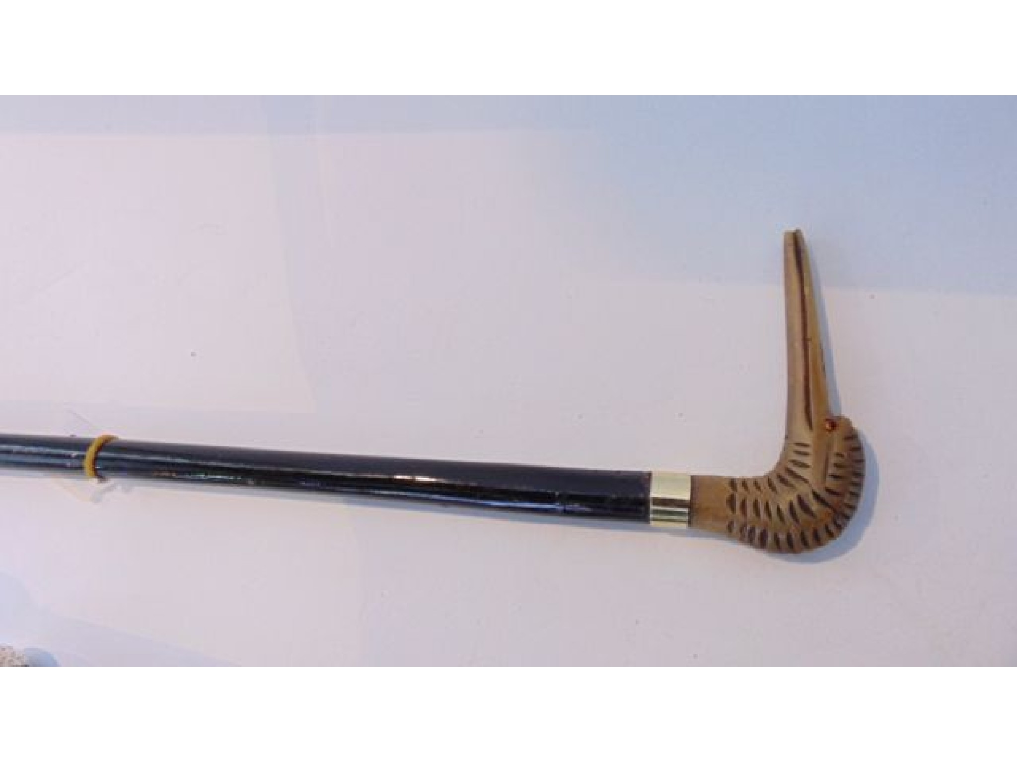 Appraisal: An ebonised walking stick terminating in a carved horn handle