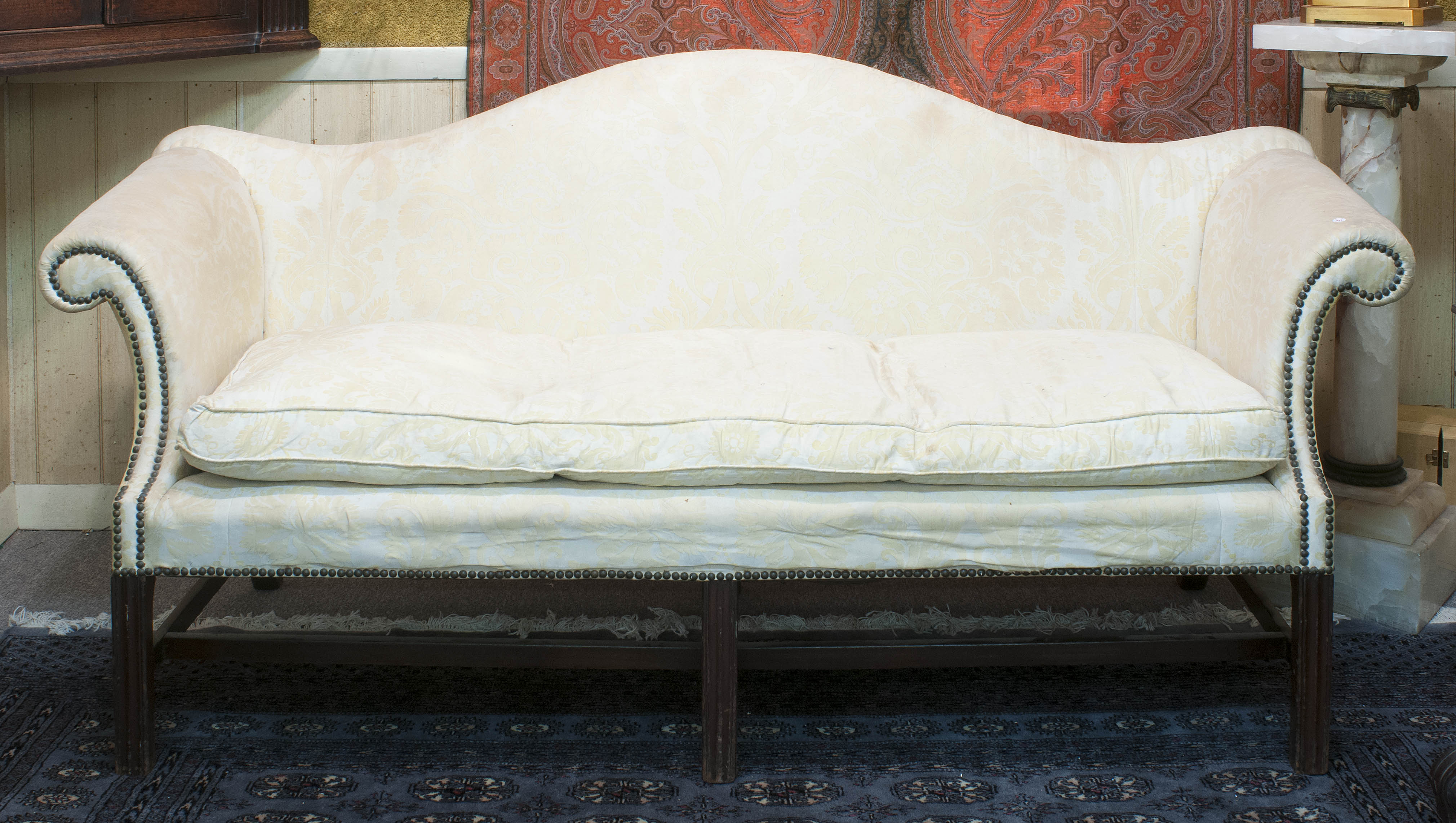 Appraisal: CHIPPENDALE-STYLE CAMELBACK SOFA th CenturyIn pale yellow upholstery with brass