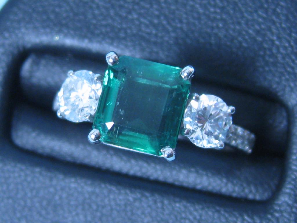 Appraisal: A three stone Emerald and Diamond Ring the square-cut emerald