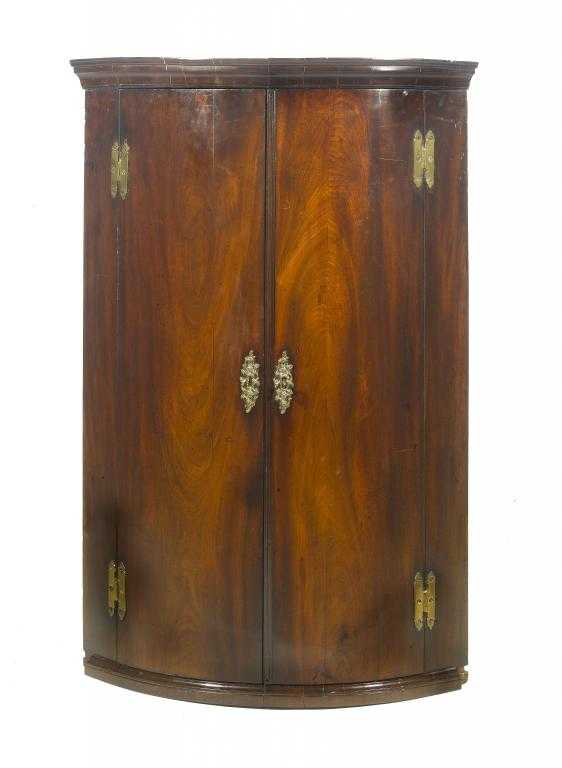 Appraisal: A GEORGE III MAHOGANY BOW FRONTED CORNER CUPBOARD the interior