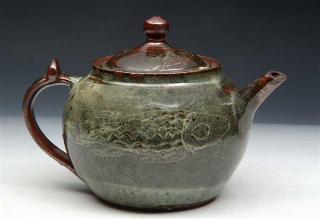 Appraisal: AN ABUJA STONEWARE TEAPOT with incised fish designs a Studio