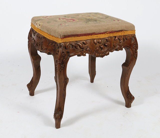 Appraisal: A CONTINENTAL CARVED WALNUT OVERSTUFFED UPHOLSTERED STOOL with acanthus leaf