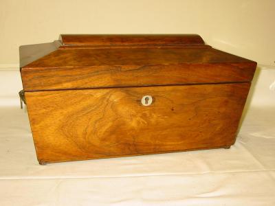 Appraisal: A ROSEWOOD TEA CADDY of sarcophagus form with moulded top