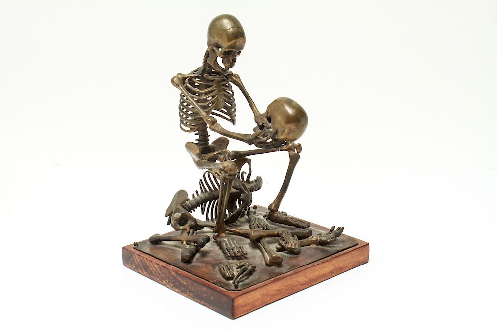 Appraisal: Human Skeleton Holding a Skull Brass Sculpture Human skeleton Holding