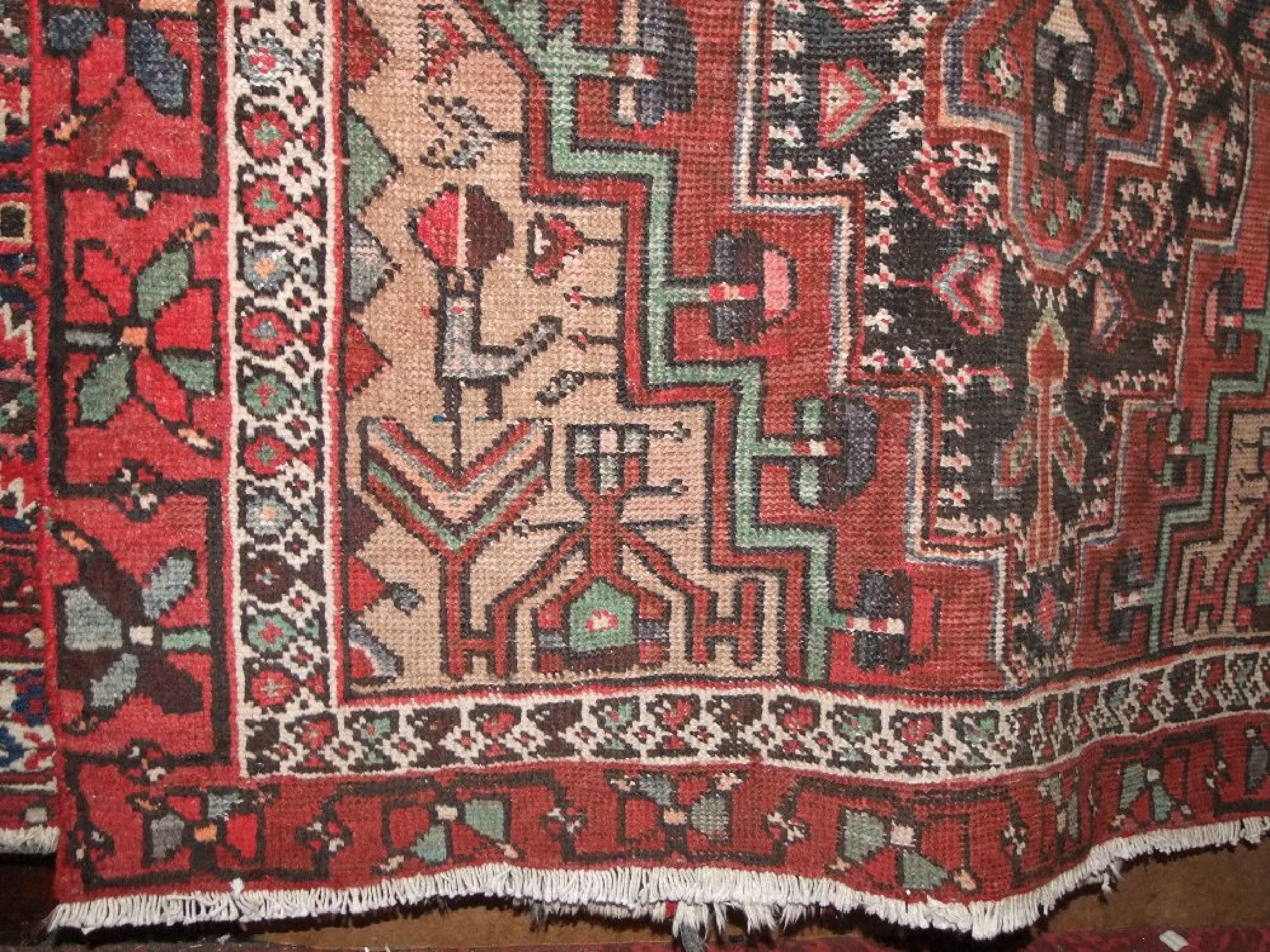 Appraisal: An eastern wool carpet with red ground field geometric detail