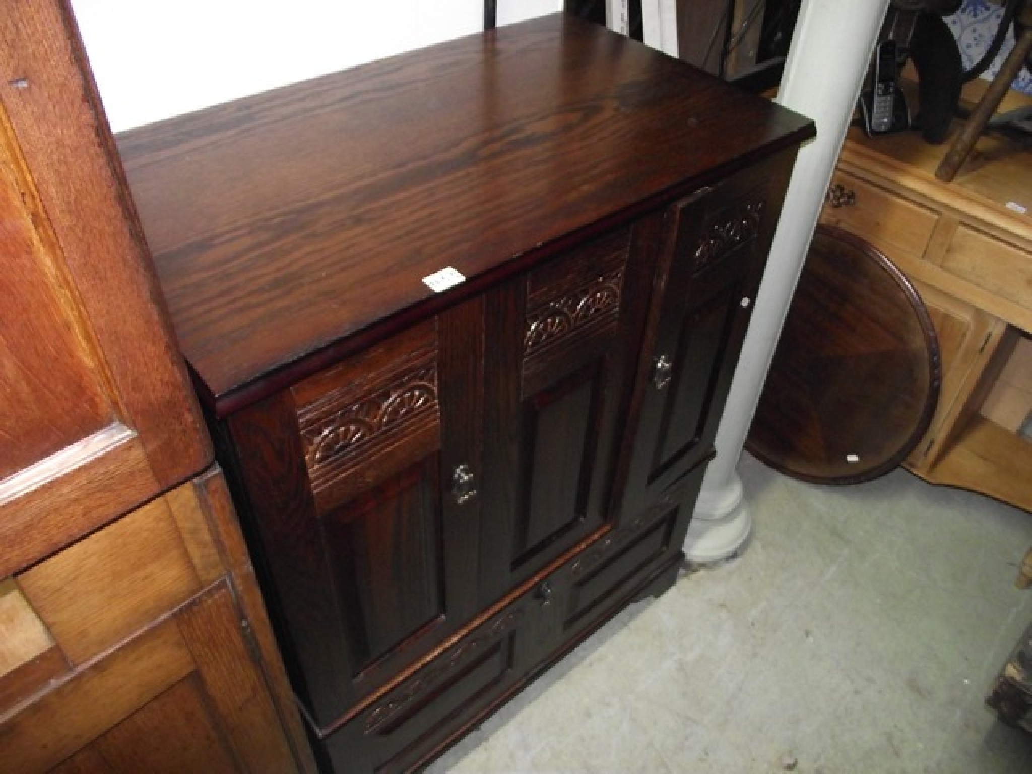 Appraisal: A reproduction oak side cupboard partially enclosed by panelled doors