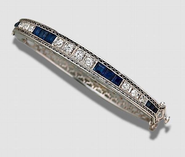 Appraisal: A diamond sapphire and fourteen karat white gold bangle bracelet