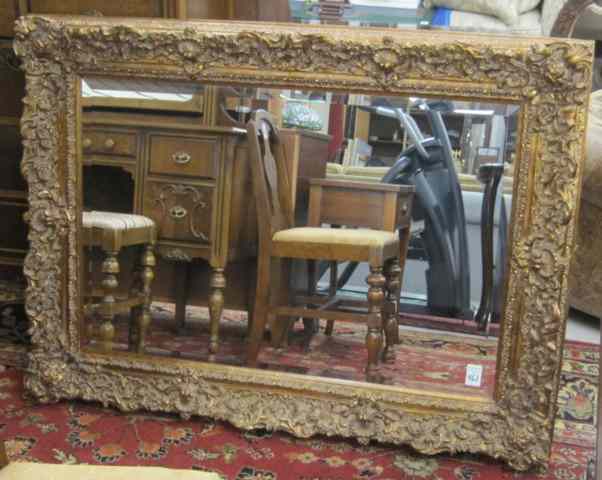 Appraisal: RECTANGULAR WALL MIRROR with ornate gold molded frame Overall dimensions