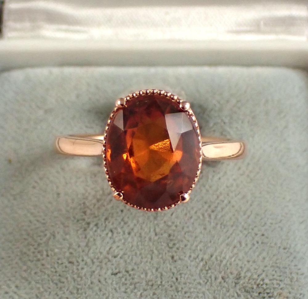 Appraisal: HESSONITE GARNET AND FOURTEEN KARAT ROSE GOLD RING The solitaire